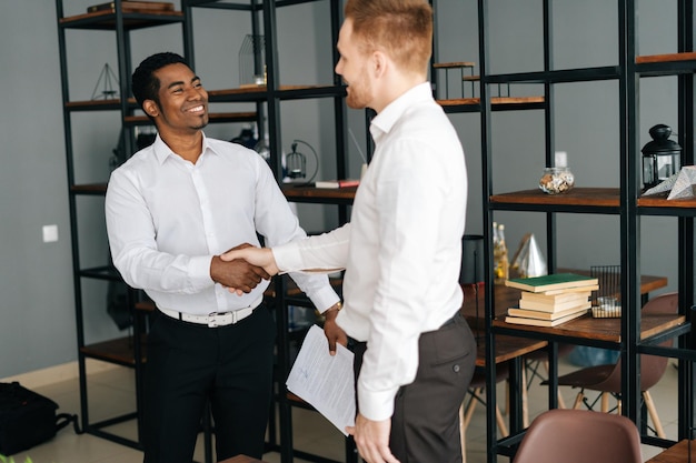 Diverse zakenpartners schudden elkaar de hand in de kantoorhal