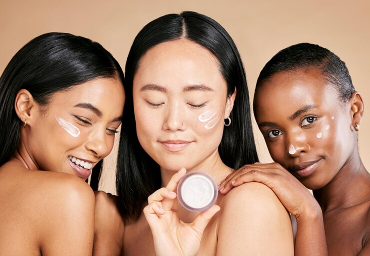 Foto diversiteit gezichts- en crèmeproduct door vrouwen in studio voor huidverzorging, wellness en verzorging op bruine achtergrond schoonheid anders en vrienden per meidengroep ontspannen met gezichtsmasker en huidbehandeling