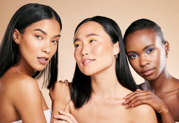 Diversiteit huidverzorging en vrouwen met cosmetica, dermatologie en wellness op bruine studio achtergrond Multiraciale make-up en dames met een gezonde, gladde en heldere huid voor vertrouwen en welzijn