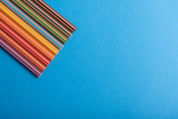 Photo diversity color rainbow of pencils over plain desk