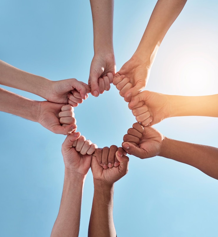 Photo diversity fist pump and hands in a circle together for unity collaboration and teamwork solidarity empowerment and closeup of a group of multiracial people in a round shape by a sky background