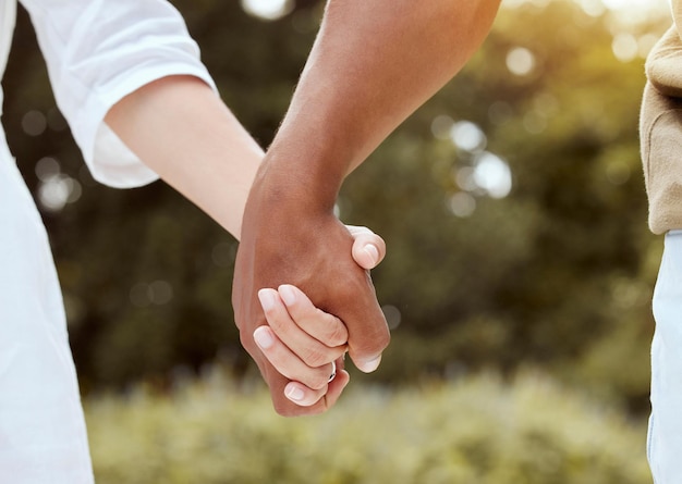 Diversity holding hands and couple being romantic support and being together for relationship marriage and unity Multiracial hand gesture and interracial for romance outdoor holiday and union