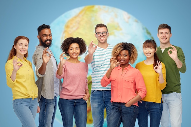 Foto diversità, razza, etnia e concetto di persone - gruppo internazionale di uomini e donne felici e sorridenti che mostrano il segno della mano ok sopra il bianco