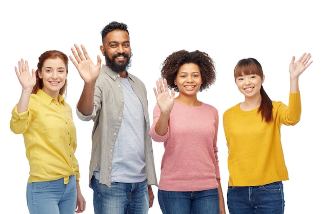 Foto concetto di diversità, razza, etnia e persone - gruppo internazionale di uomini e donne sorridenti felici che agitano le mani sul bianco