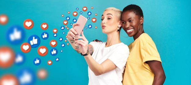 Diversity social media icons or women take a selfie for content or online post on blue background Love emojis friends or happy girls take fun pictures together on mobile app or network in studio