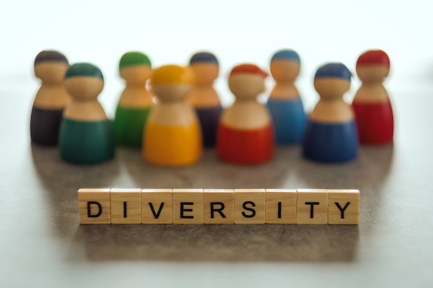 DIVERSITY word on wooden blocks with  a group of different people in the background