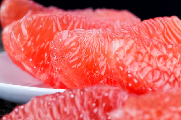 Divided into whole slices delicious sour red grapefruit on the table