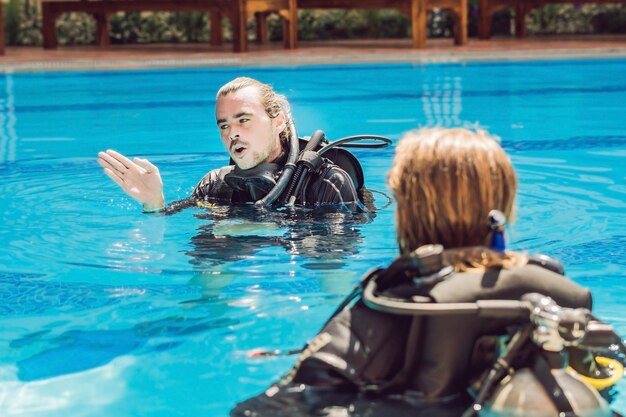 Diving instructor and students. Instructor teaches students to dive