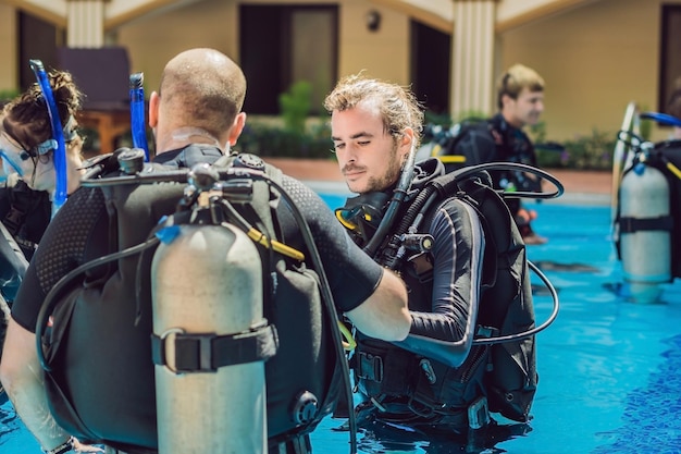 Diving instructor and students. Instructor teaches students to dive