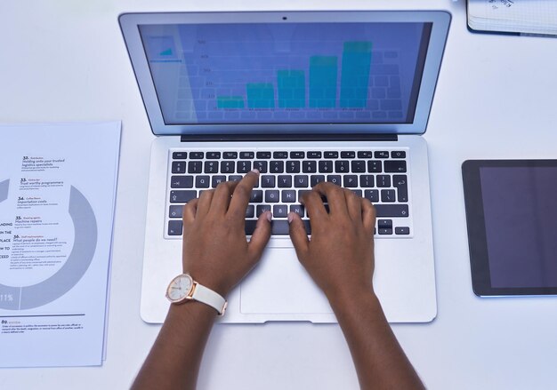 Diving into the information some more High angle shot of an unrecognisable businesswoman using a laptop in an office