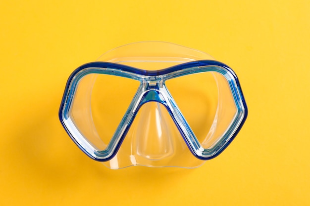 Diving mask on yellow background, space for text