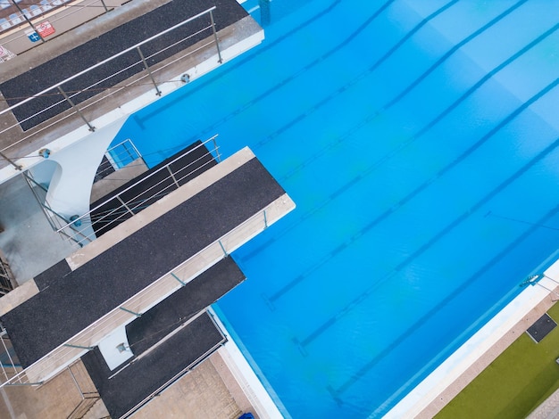 The diving towers stand tall their vibrant presence contrasting against the crystal blue waters of the pool Aerial view