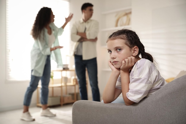 Divorce concept Angry couple arguing at home focus on their sad daughter