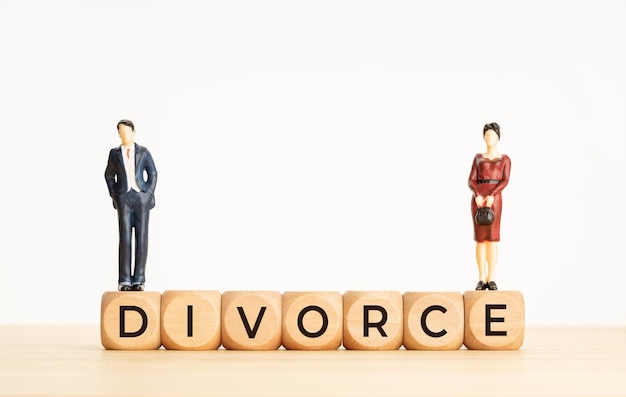離婚の概念。木製の立方体のブロックと女性と男性の置物についての言葉。コピースペース