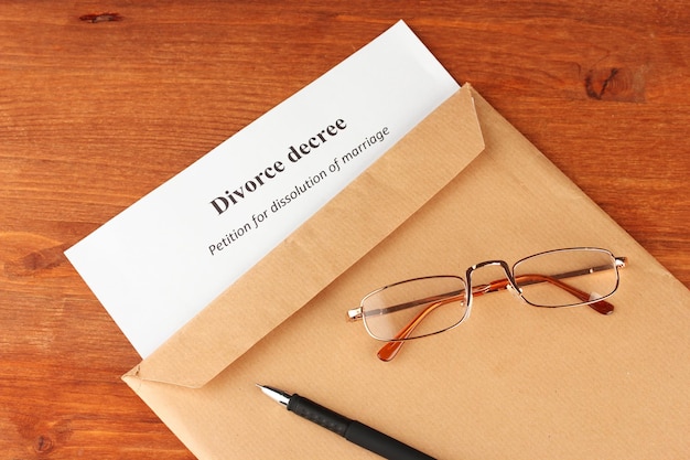 Divorce decree and envelope on wooden background