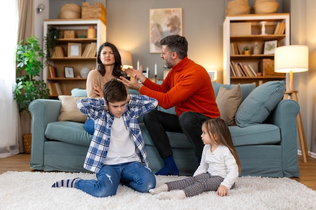 Photo divorce and domestic violence portrait of upset son and daughter while their angry parents fighting in the background depressed children feeling lonely