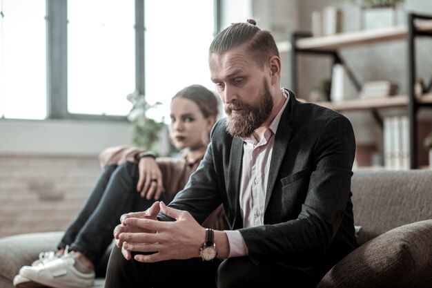 Divorce with wife. Bearded father feeling emotional while speaking about divorce with wife to his daughter