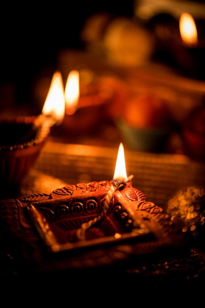 Diwali diya or lighting in the night with gifts, flowers over moody scene