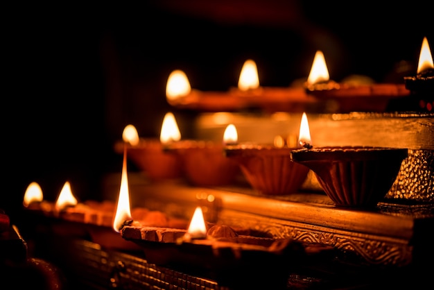 Diwali diya or lighting in the night with gifts, flowers over moody scene