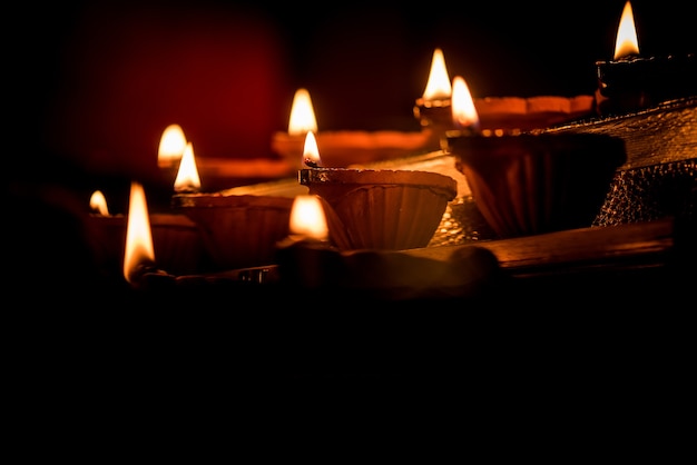 Diwali diya or lighting in the night with gifts, flowers over moody scene
