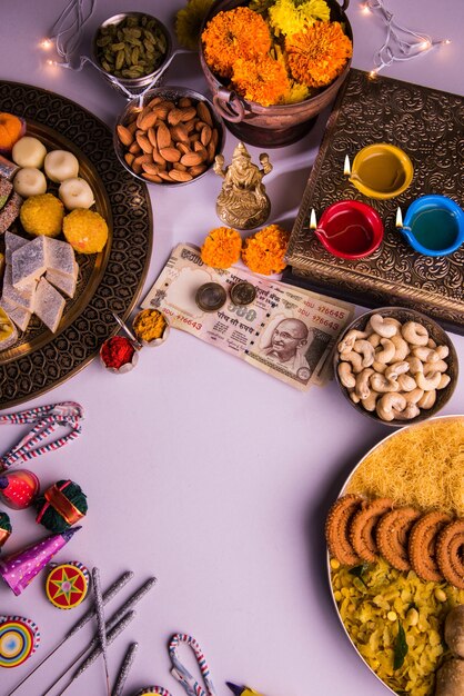 Diwali en voorbereiding voor laxmi of lakshmi pooja met elementen zoals diya, bankbiljetten, snoep, bloemen, snacks, haldi en kumkum