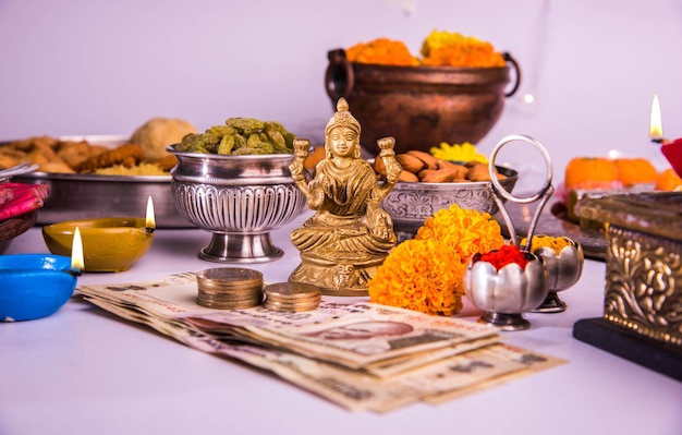 Diwali en voorbereiding voor laxmi of lakshmi pooja met elementen zoals diya, bankbiljetten, snoep, bloemen, snacks, haldi en kumkum