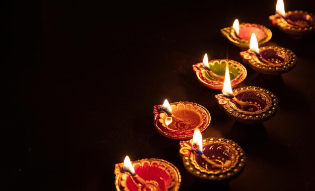 Diwali Hindu festival of lights celebration Diya oil lamps against dark background