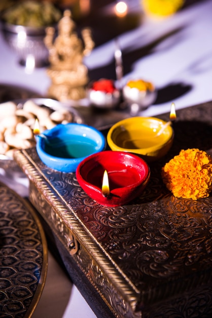 Photo diwali and preparation for laxmi or lakshmi pooja with elements like diya, currency notes, sweets, flowers, snacks, haldi and kumkum
