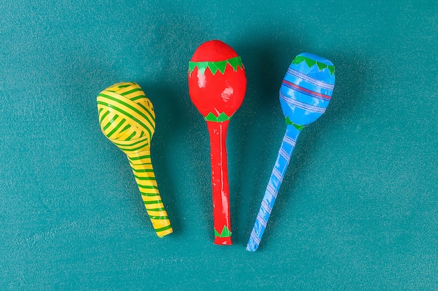 Фото diy cinco de mayo maracas из яиц, ложек и злаков на зеленом фоне.