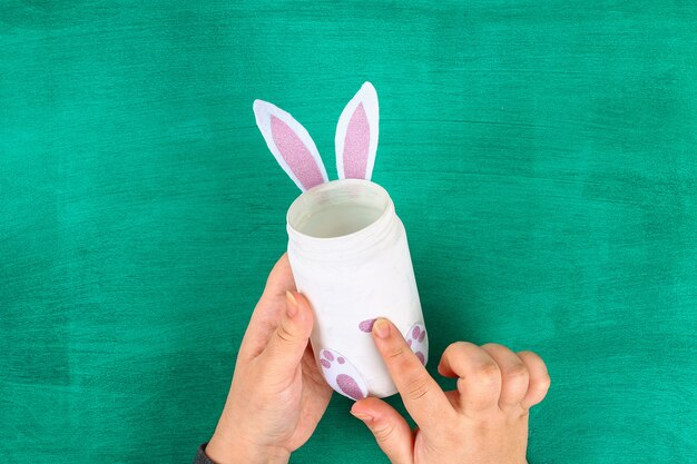 DIY Easter vase bunny from glass jar, felt, googly eyes on a green background