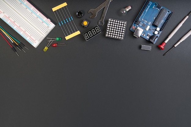 Photo diy electronic maker tools components on black background.