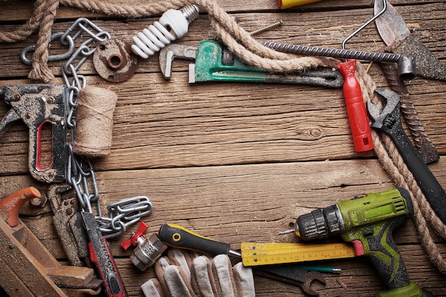 DIY, frame from a pile of old work tools and accessories on a wooden table in the workshop. Do It Yourself concept.