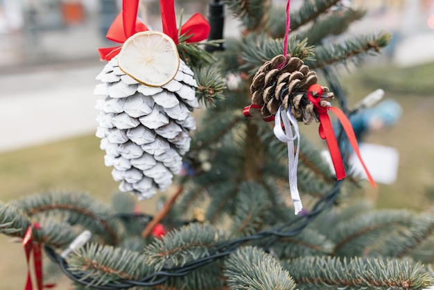 DIY handmade decoration on Christmas tree White painted pine cone