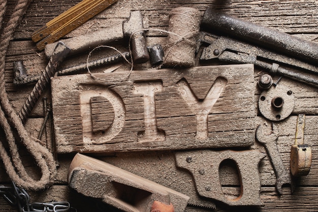 DIY letters on a wooden board on the background of working tools