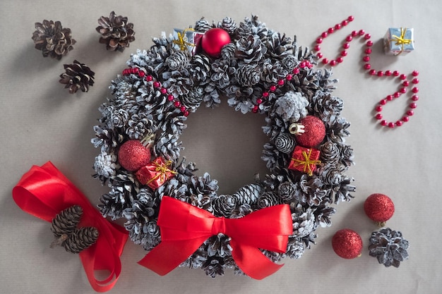 Diy step  top view of a christmas wreath of fir cones decorative toys and ribbons