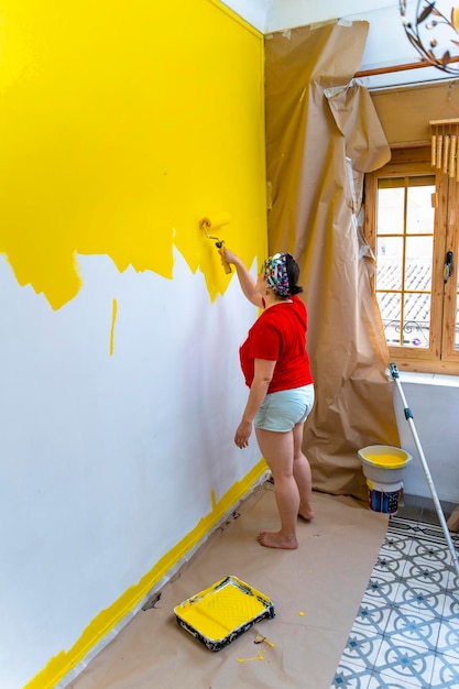 DIY Wall Makeover MiddleAged Woman Creating a Yellow Oasis