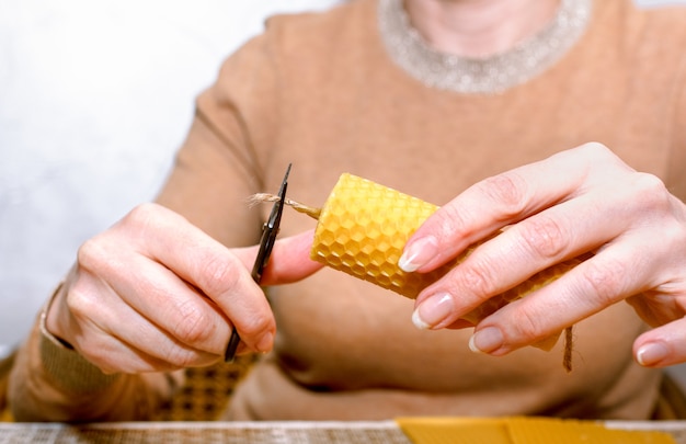 Processo di fabbricazione di candele di cera fai da te. donna che fa una candela di cera decorativa