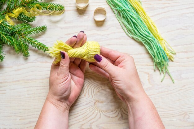 Photo diy winter craft, small beanie. twist the threads and thread them into the ring.