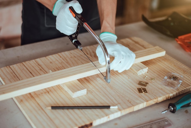 DIY woodworking Man sawing wood Close up