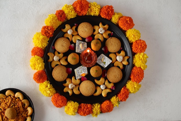 Foto lampade diya accese durante la celebrazione del diwali, dolci dell'india, piatto di dolci diwali, happy diwali