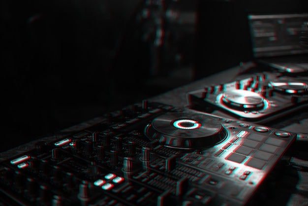 Photo dj console for mixing music with blurry people dancing at a nightclub party. black and white with 3d glitch virtual reality effect