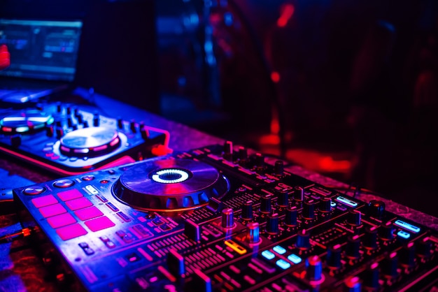 DJ-console voor het mixen van muziek met wazige mensen die dansen op een nachtclubfeest