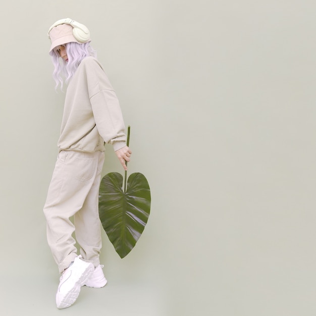 Dj girl posing in studio. urban style. hip-hop. dancer. fresh casual beige outfit. fashion monochrome aesthetic colours.