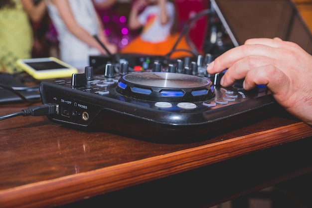 DJ Hands создает и регулирует музыку на микшере диджейской консоли на концерте панель контроллера микшера на открытом воздухе DJ для воспроизведения музыки и вечеринок