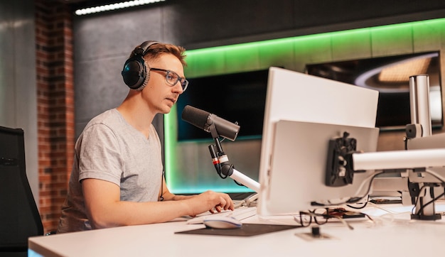 The dj hosts the program and communicates with the audience on\
air at the radio station the announcer reads the news a male radio\
host speaks into a microphone and records a podcast