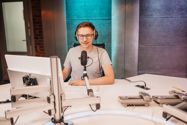 The DJ hosts the program and communicates with the audience on air at the radio station The announcer reads the news A male radio host speaks into a microphone and records a podcast