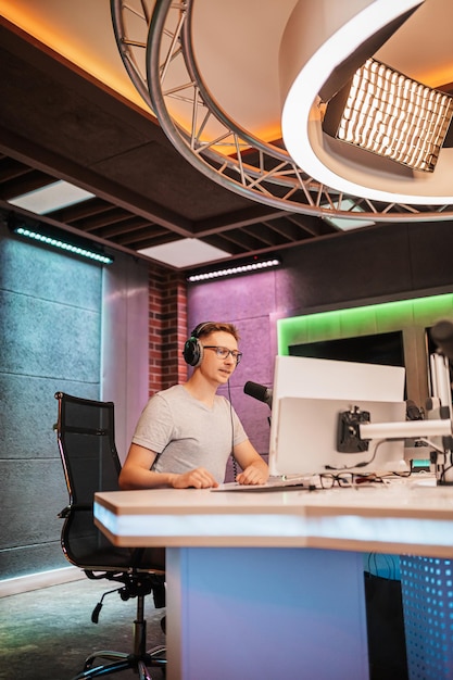 The DJ hosts the program and communicates with the audience on air at the radio station The announcer reads the news A male radio host speaks into a microphone and records a podcast