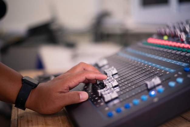 DJ is adjusting the volume of the sound. Professional audio mixing console