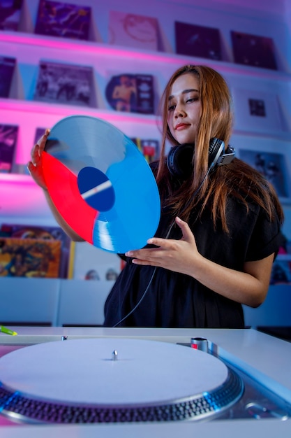 Dj latina mezclando musica en una tienda de discos con un tornamesa y discos de vinil