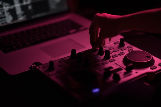 DJ mixer disco verlicht door schijnwerpers in de club